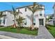 Modern, two-story home featuring a clean white exterior, palm trees, and manicured landscaping at 6023 Cat Claw Ln, Bradenton, FL 34210