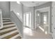 Bright foyer with wood and white staircase, complemented by neutral paint and tile floors at 6023 Cat Claw Ln, Bradenton, FL 34210