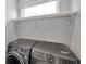 Convenient laundry room setup with overhead shelving and modern, front-load washer and dryer at 6023 Cat Claw Ln, Bradenton, FL 34210