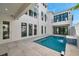Modern backyard pool with water feature and travertine tile deck, bordered by modern architecture at 6023 Cat Claw Ln, Bradenton, FL 34210