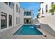 Backyard pool area with water feature, travertine tile, and modern architecture at 6023 Cat Claw Ln, Bradenton, FL 34210