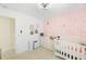 Pink Bedroom with star decals, crib, dresser, and neutral tile floors at 6248 Tabogi Trl, Wesley Chapel, FL 33545