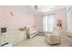 Pink Bedroom with star decals, crib, dresser, and comfortable seating at 6248 Tabogi Trl, Wesley Chapel, FL 33545