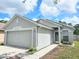 Home exterior featuring a two-car garage, walkway and manicured lawn at 6248 Tabogi Trl, Wesley Chapel, FL 33545