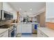 Modern kitchen features white cabinets, stainless steel appliances, and views into the living area at 6277 Bahia Del Mar Blvd # 110, St Petersburg, FL 33715