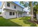 Spacious backyard with lush green grass, a covered patio, and a white two-story house at 803 W Woodlawn Ave, Tampa, FL 33603