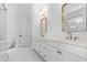 Bathroom with dual sinks, modern vanity, decorative mirrors, and a soaking tub at 803 W Woodlawn Ave, Tampa, FL 33603