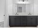 Elegant bathroom featuring double vanity with black cabinets, white countertop and an oversized mirror at 803 W Woodlawn Ave, Tampa, FL 33603