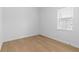 Empty bedroom with light hardwood floors, white walls, and a window at 803 W Woodlawn Ave, Tampa, FL 33603