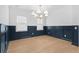 Dining room featuring wood floors, wainscoting, modern lighting, and bright windows at 803 W Woodlawn Ave, Tampa, FL 33603