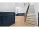 Bright entryway with elegant staircase, wood floors, and stylish navy blue wainscoting at 803 W Woodlawn Ave, Tampa, FL 33603