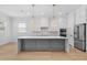 Modern kitchen with white cabinets, gray island, stainless steel appliances and stylish pendant lighting at 803 W Woodlawn Ave, Tampa, FL 33603