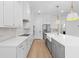 Bright kitchen with stainless steel appliances, center island, and white cabinetry with gold hardware at 803 W Woodlawn Ave, Tampa, FL 33603
