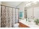 Bright bathroom featuring a white vanity, decorative shower curtain, and a modern sink with plants at 9481 Highland Oak Dr # 1616, Tampa, FL 33647