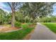 Scenic walking path with a bench surrounded by lush greenery, perfect for relaxing strolls at 9481 Highland Oak Dr # 1616, Tampa, FL 33647