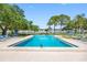 Community pool is surrounded by lounging chairs and lush trees at 1000 79Th N Ave # 211, St Petersburg, FL 33702