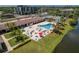 Aerial view of pool with a hot tub, lounge area, and tennis courts, all surrounded by lush landscaping at 10035 63Rd N Ave # 23, St Petersburg, FL 33708