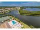 Wide aerial view showcasing tennis courts, pool, and pond surrounded by condos at 10035 63Rd N Ave # 23, St Petersburg, FL 33708