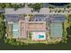 Aerial view of condos featuring a pool, tennis courts, lush landscaping, and parking at 10035 63Rd N Ave # 23, St Petersburg, FL 33708