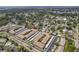 Expansive aerial view showcasing the condo complex with mature trees, a pond, and its prime location near the water at 10035 63Rd N Ave # 23, St Petersburg, FL 33708