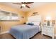 Inviting bedroom featuring a ceiling fan, comfortable bed, and a bright window with a nightstand at 10035 63Rd N Ave # 23, St Petersburg, FL 33708