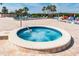 Community hot tub next to the swimming pool, with lounge chairs and tropical trees around at 10035 63Rd N Ave # 23, St Petersburg, FL 33708