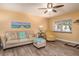 Comfortable living room with wood-look flooring, neutral-toned furniture, ceiling fan and natural light from the window at 10035 63Rd N Ave # 23, St Petersburg, FL 33708