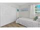 Cozy bedroom with wood floors, closet, and white walls creating a bright and airy space at 10074 Bahama Ct, Seminole, FL 33776