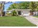 Charming single-story home with lush green lawn, modern front door, and attached garage in a desirable neighborhood at 10074 Bahama Ct, Seminole, FL 33776
