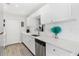 Renovated kitchen features stainless steel appliances, white cabinetry and light countertops at 10074 Bahama Ct, Seminole, FL 33776