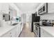 Modern kitchen with white cabinets, stainless steel appliances, sleek countertops, and stylish fixtures at 10074 Bahama Ct, Seminole, FL 33776