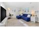 Cozy living room with comfortable blue sectional sofa, beach-themed decor, and bright natural lighting from window at 10074 Bahama Ct, Seminole, FL 33776