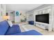 Inviting living space featuring a plush blue sofa, modern entertainment center, and stylish decor elements at 10074 Bahama Ct, Seminole, FL 33776