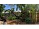 Landscaped backyard features beautiful trees, lush greenery, and a charming wooden fence for added privacy at 1107 S Prospect Ave, Clearwater, FL 33756