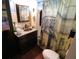 Cozy bathroom showcasing an ornate shower curtain, granite sink, and wood floor at 1107 S Prospect Ave, Clearwater, FL 33756