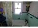 Relaxing bath/shower with shower curtains, teal tile accents and grab bar for accessibility at 1107 S Prospect Ave, Clearwater, FL 33756