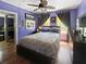 Charming bedroom with hardwood floors, ceiling fan, comfortable bed, and abundant natural light at 1107 S Prospect Ave, Clearwater, FL 33756