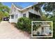 Charming two-story home with white siding, a carport, and a quaint guest house surrounded by lush greenery at 1107 S Prospect Ave, Clearwater, FL 33756