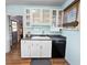 Bright kitchen area with white cabinets, a black dishwasher and neutral countertops at 1107 S Prospect Ave, Clearwater, FL 33756