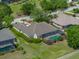 Aerial view of the home with a screened in pool and lush landscaping at 13538 Thoroughbred Dr, Dade City, FL 33525