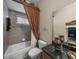 Bathroom featuring a tiled shower with a shower curtain and black marble vanity at 13538 Thoroughbred Dr, Dade City, FL 33525