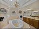 Elegant bathroom featuring a jacuzzi tub, decorative chandelier, and tiled walls at 13538 Thoroughbred Dr, Dade City, FL 33525
