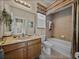 Well-lit bathroom with tub, tile surround, decorative accents, and a wood vanity at 13538 Thoroughbred Dr, Dade City, FL 33525