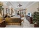 Large bedroom with four-poster bed, wooden furniture, tray ceiling and seating area at 13538 Thoroughbred Dr, Dade City, FL 33525