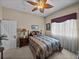 Inviting bedroom with ceiling fan, large window, and queen bed, exuding a warm ambiance at 13538 Thoroughbred Dr, Dade City, FL 33525