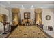 Bedroom features a four-poster bed, tray ceiling, and decoratively framed mirror at 13538 Thoroughbred Dr, Dade City, FL 33525