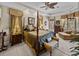 Spacious bedroom with four-poster bed, sitting area, and tray ceiling with fan at 13538 Thoroughbred Dr, Dade City, FL 33525
