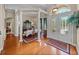 Inviting foyer with hardwood floors, decorative windows and doors, chandelier, and view into dining room at 13538 Thoroughbred Dr, Dade City, FL 33525