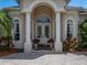 Elegant front entrance with white columns, arched windows, and a brick paved walkway leading to the double doors at 13538 Thoroughbred Dr, Dade City, FL 33525