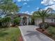 Beautiful front exterior with circular driveway, lush landscaping, and a charming, inviting facade at 13538 Thoroughbred Dr, Dade City, FL 33525